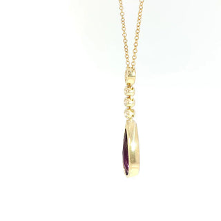Gold necklace with a purple gemstone pendant on a white background