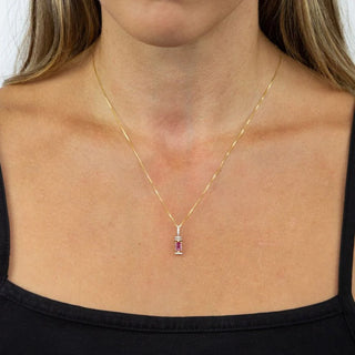 Gold necklace with a pendant worn by a person