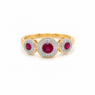 A yellow gold three-stone ring featuring a large round ruby center stone surrounded by a halo of small clear stones, with two smaller matching ruby and diamond clusters on either side, shown on a plain white background.