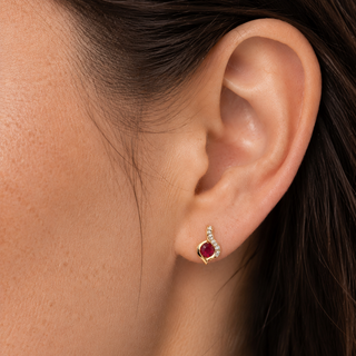Close-up of an ear wearing a red gemstone earring.