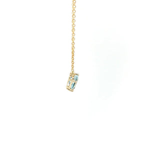 A gold chain necklace with a small cylindrical charm featuring light blue and white enamel detailing, shown against a plain white background.