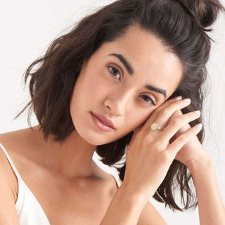 Woman with styled hair and a ring on a white background