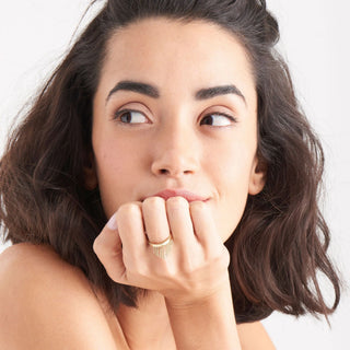 Woman with a thoughtful expression, looking to the side with her hand on her chin.