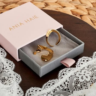 Gold rings in a 'Ania Haie' box on a lace tablecloth