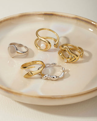 Set of gold and silver rings on a ceramic dish