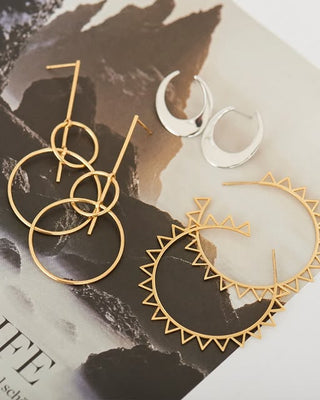Gold and silver earrings on a magazine page