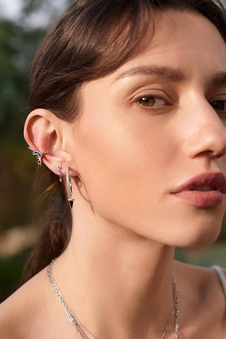 Close-up of a woman wearing earrings with a blurred natural background