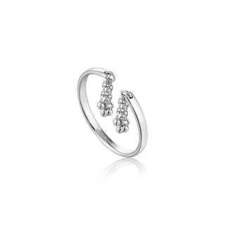 A silver tassel drop ring with a band style that is adjustable, featuring two tassels on the top.