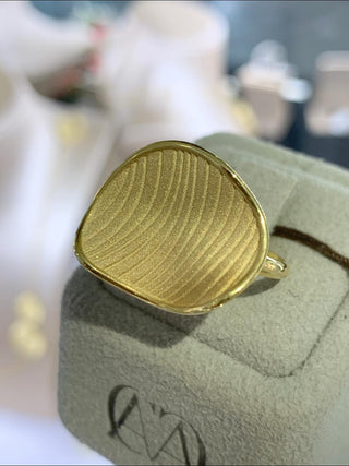 Gold ring on a textured surface with blurred background