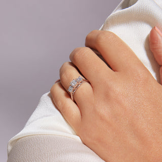 Close-up of a hand wearing a diamond ring on a light gray background