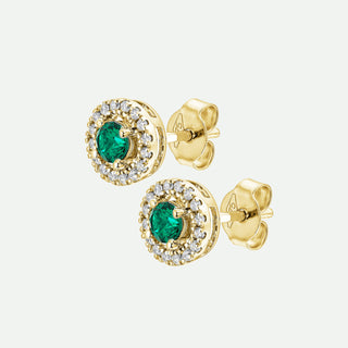 Gold earrings with green gemstones on a white background