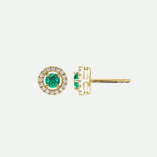 Gold earrings with green gemstones on a light gray background