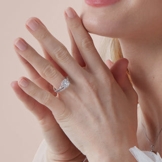 Close-up of a hand wearing a diamond ring on a soft pink background
