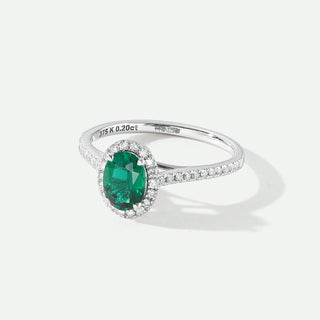 Silver ring with a green gemstone on a white background