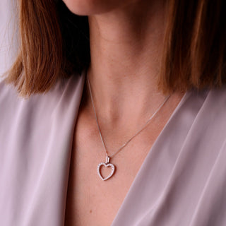 Heart-shaped necklace worn by a person with a soft background