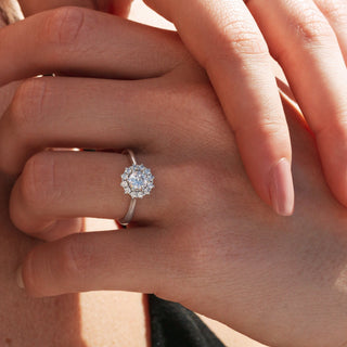 Close-up of a hand wearing a diamond ring with a soft focus background