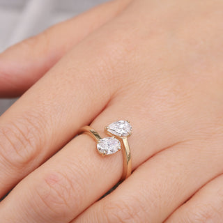 Yellow gold ring with two pear-shaped diamonds on a hand