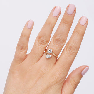 Hand wearing a diamond ring with a plain background