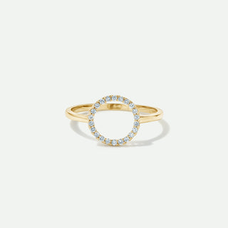 Gold ring with small diamonds on a light gray background