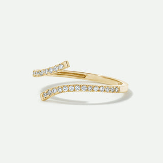 Gold ring with diamonds on a light beige background