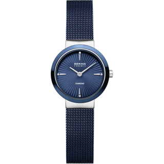 A women's analog watch by Bering , featuring a textured navy blue mesh strap, a matching blue sunburst dial with silver-tone hands and indices, and a silver-tone case.
