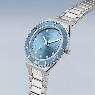 Silver watch with a blue face on a light gray background
