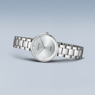 Silver watch with a metallic band on a light gray background