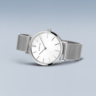 Silver watch with a mesh band on a light gray background