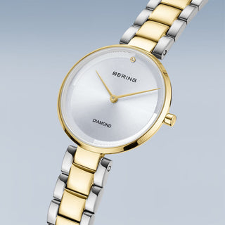 Gold and silver Bering watch on a light gray background