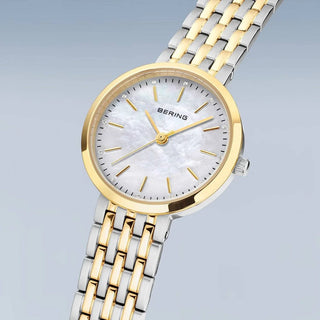 Two-tone gold and silver watch with a white face on a light gray background