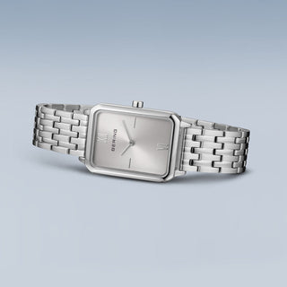 Silver watch with a rectangular face on a light gray background
