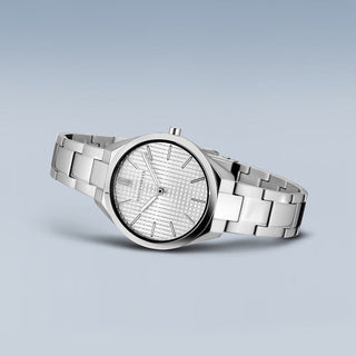 Silver wristwatch with a detailed face on a light gray background