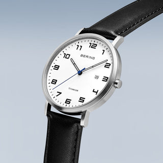 Bering watch with black leather strap and white dial on a light gray background