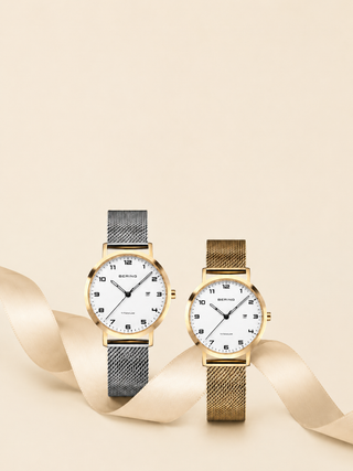 Two watches, one gold and one silver, on a beige background with ribbons.