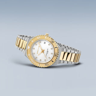 Two-tone watch with gold and silver straps on a light gray background