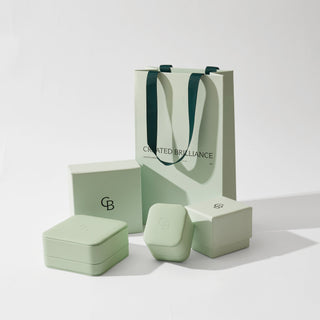 Jewelry packaging set with a green box, lid, and carrying bag on a white background.