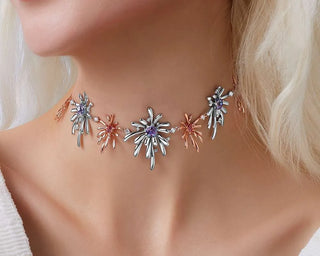 Necklace with star-shaped pendants on a person wearing a white top.