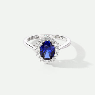 whit gold ring with a blue gemstone on a white background