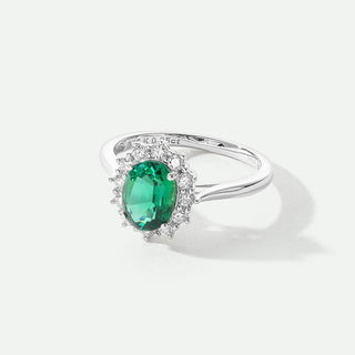 White Gold ring with a green gemstone on a white background