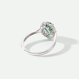 Silver ring with a green gemstone on a white background