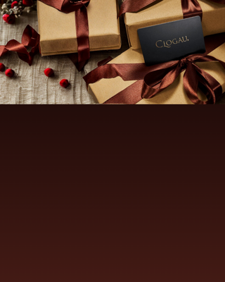 Gift boxes with Clogau branding on a wooden surface.