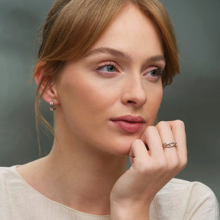 Woman with hand on chin against a gray background