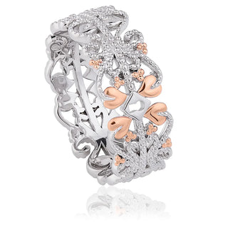 Silver and rose gold ring with floral design on a white background