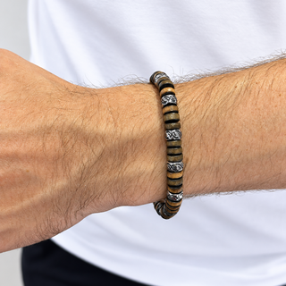 A close-up of a person's wrist wearing a beaded bracelet with alternating dark brown and black beads, accented by silver-toned metal links.