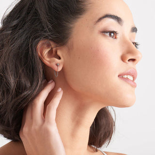 Close-up of a woman wearing an earring with a neutral background