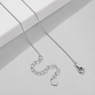 A silver chain necklace with an adjustable lobster clasp and a small heart-shaped charm engraved with 'LOVE', displayed on a light gray surface.