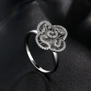 Silver ring with floral design on a black background