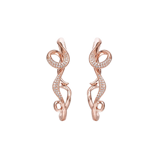 A pair of rose gold huggie hoop earrings with intricate, swirling openwork designs and pavé-set clear stones, shown on a light gray background.