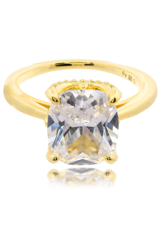 Gold ring with a large clear gemstone on a white background