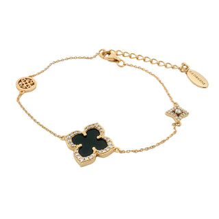 Gold bracelet with a clover-shaped black stone on a white background